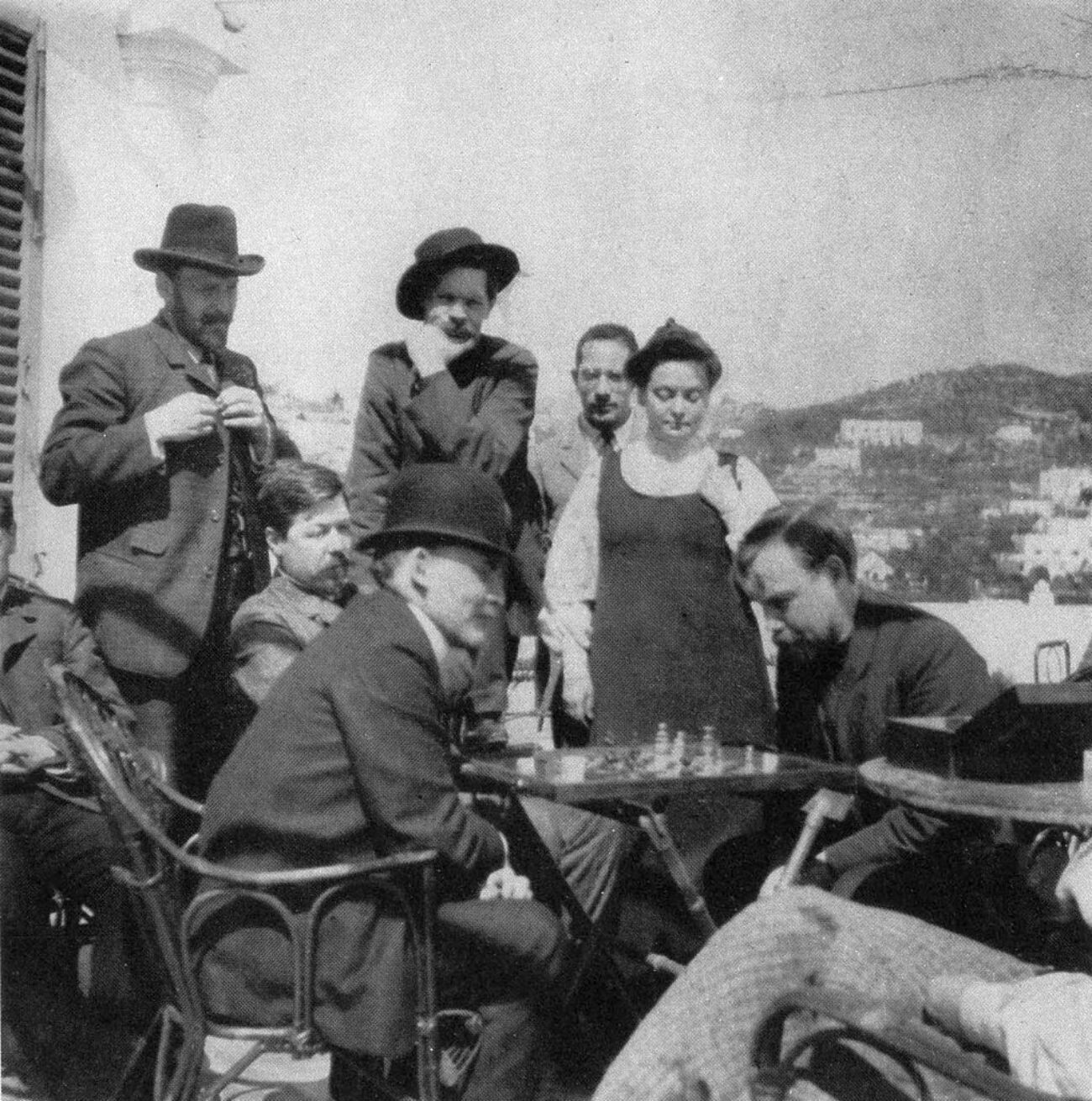 Wladimir Lenin spielt Schach mit Alexander Bogdanow, 1908, Capri. Sinowy Peschkow ist der zweite von rechts in der oberen Reihe, neben ihm Maxim Gorki.