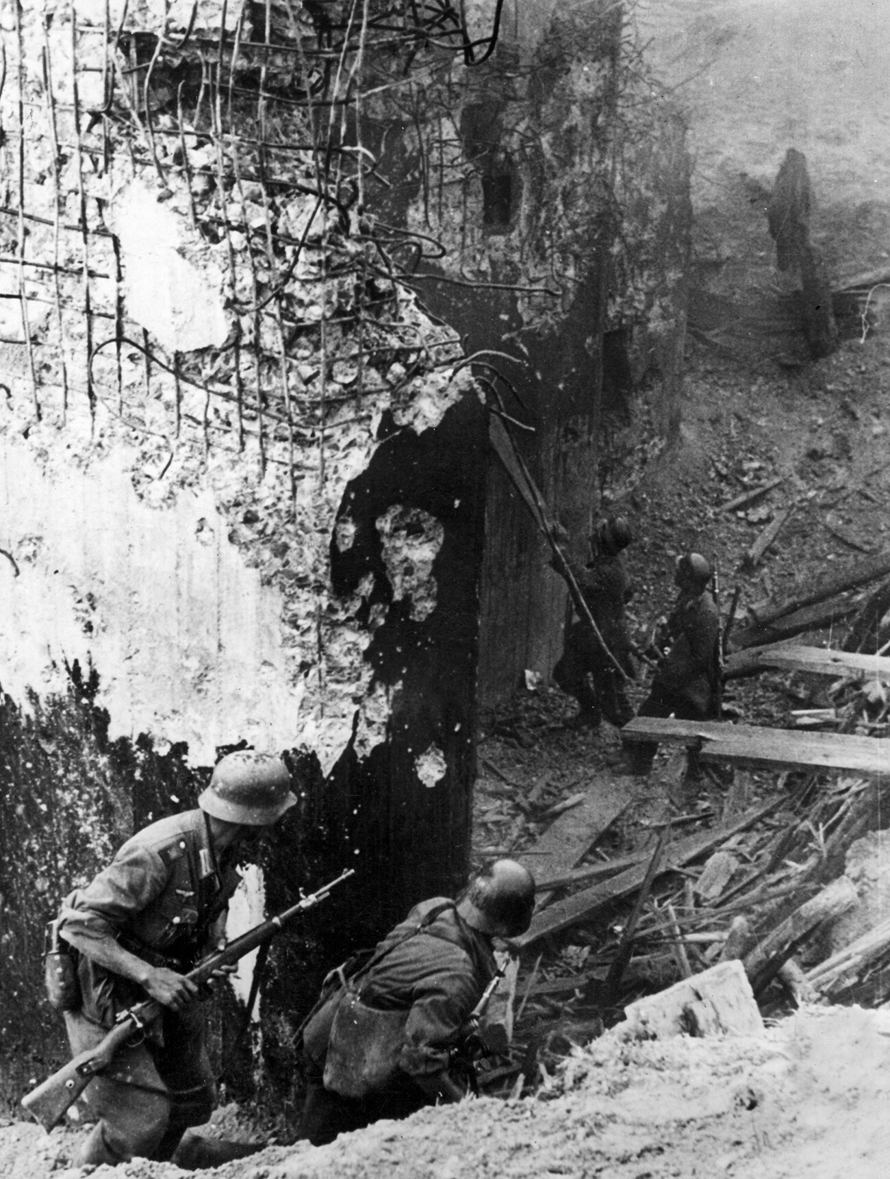 German soldiers standing at the entrance of a bunker on the 'Stalin Line' destroyed with explosive charges, July 1941.