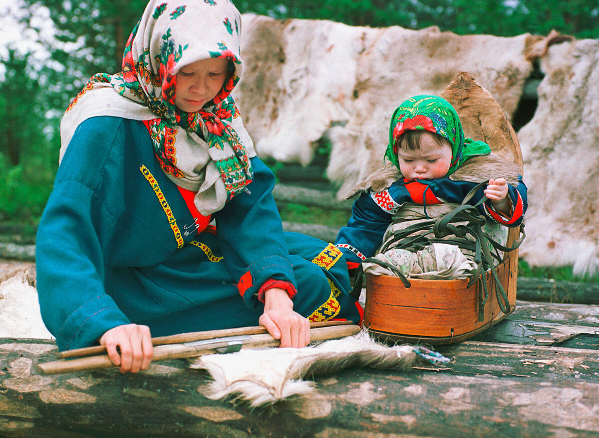 Seorang perempuan Mansi tengah mempersiapkan kulit rusa untuk pembuatan pakaian.