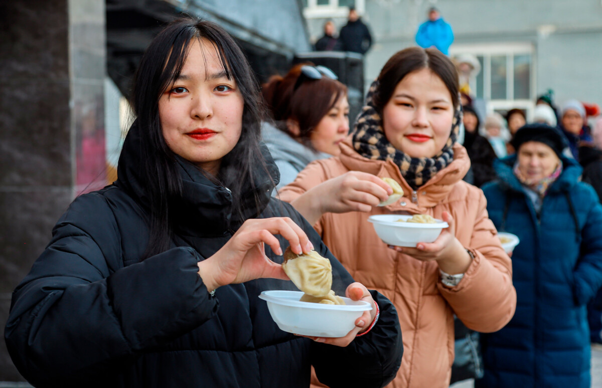 Jeunes femmes mangeant des buuzy durant le Nouvel An bouddhiste dans la région d'Irkoutsk