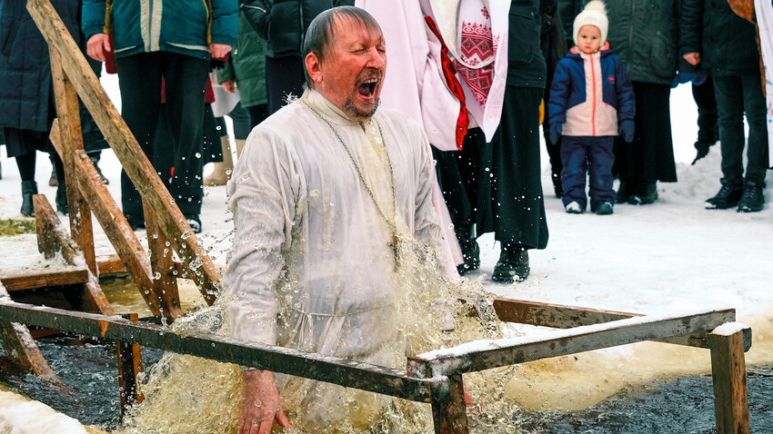 Duhovnik med potapljanjem v ledeno vodo ob praznovanju Jezusovega krsta v vasi Orlino v Leningrajski regiji