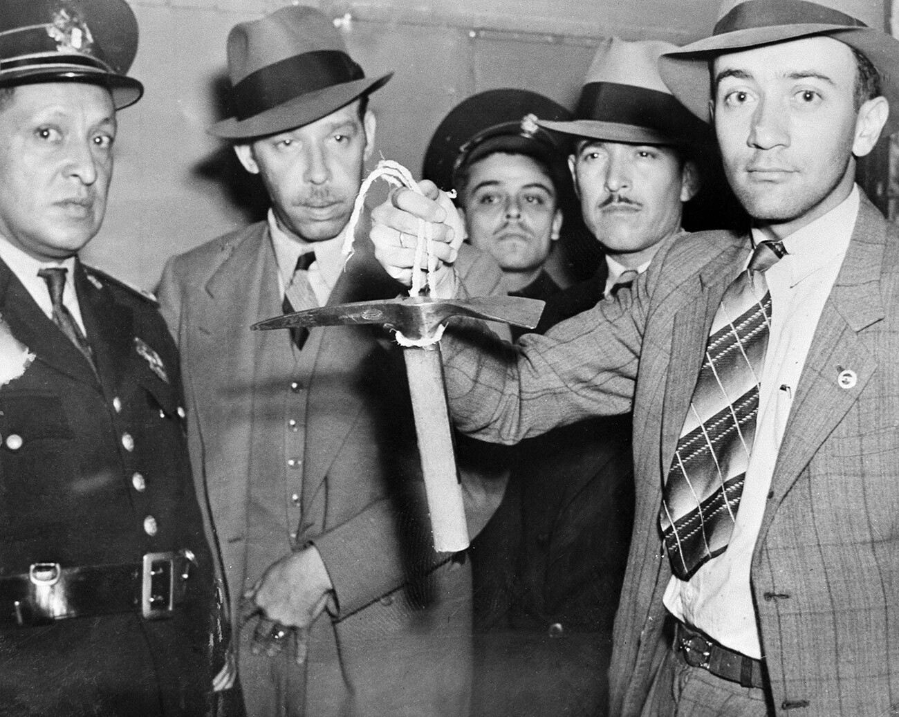 Un poliziotto messicano regge l’arma del delitto usata da Ramón Mercader per uccidere Lev Trotskij: una piccozza dal manico corto