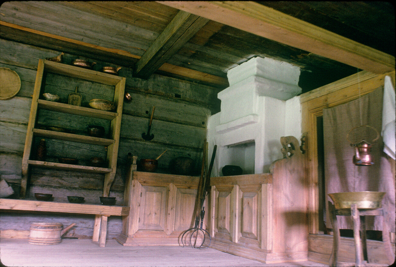 Hiša Rusinova (staroverska domačija) iz vasi Kondratjevska. Del notranjosti, ki se uporablja za obroke, z opečno pečjo na desni. Bivalni prostor za zaveso iz blaga. 27. julij 1998
