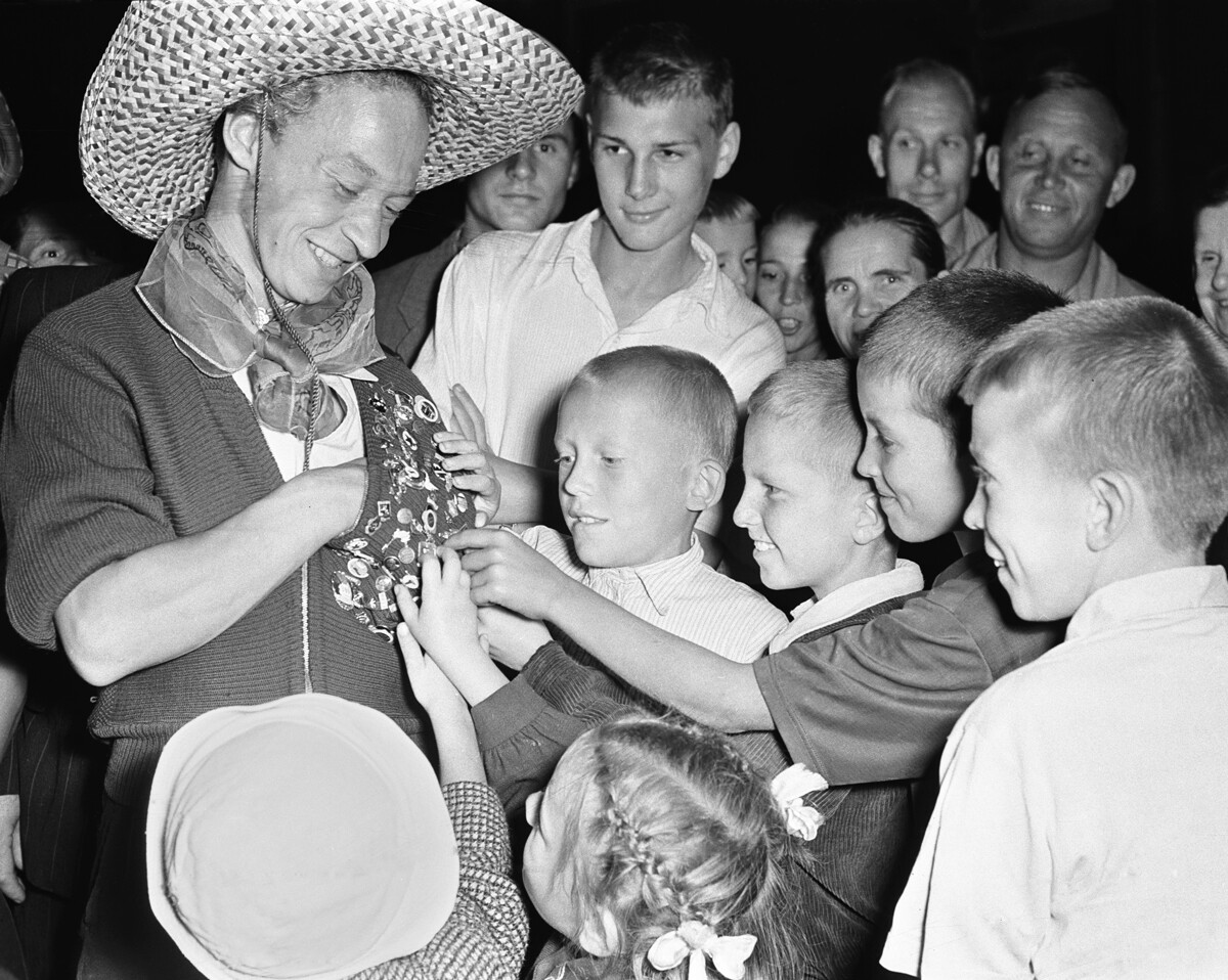 Mosca, Urss, 31 luglio 1957. L’elettricista finlandese Urpo Koponen (a sinistra) mostra la sua collezione dei distintivi del Festival internazionale della gioventù e degli studenti agli ammirati scolari moscoviti