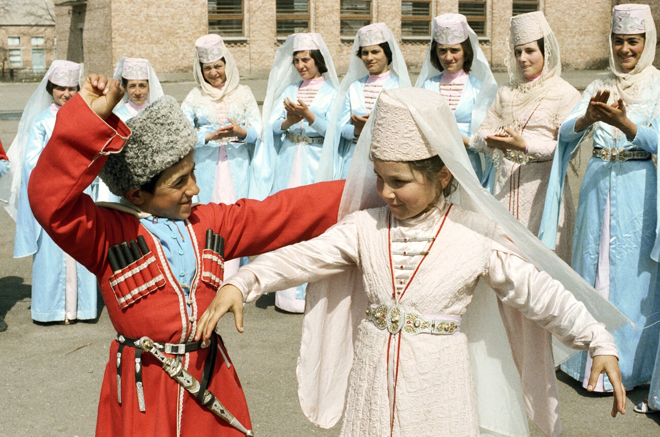 Jóvenes residentes de la aldea de Dzuarikau interpretando una danza en un concierto folclórico. República de Osetia del Norte-Alania, Rusia.