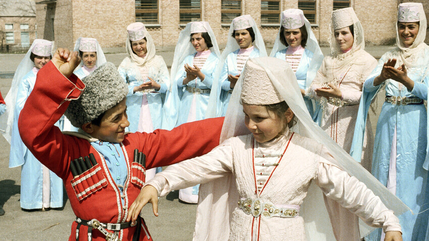 Jovens moradores de aldeia de Dzuarikau dançando em uma apresentação folclórica. República da Ossétia do Norte-Alânia.

