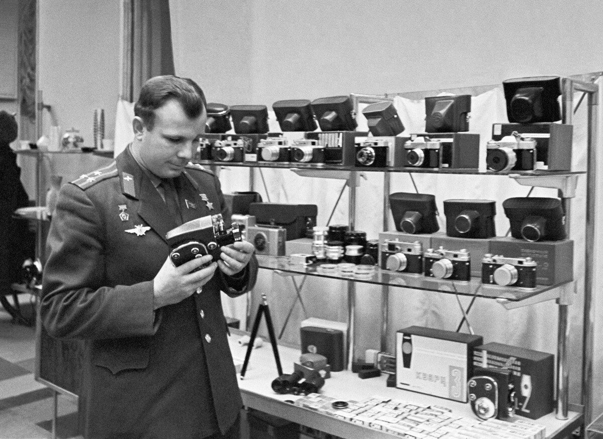 El piloto-cosmonauta soviético Yuri Gagarin mira una cámara Kvarz en una tienda 1964.
