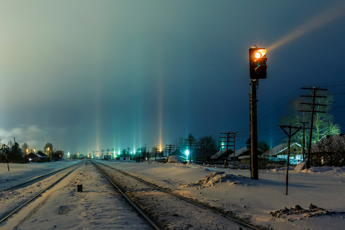 Svetlobni stebri na obzorju ob železnici na severu Rusije 
