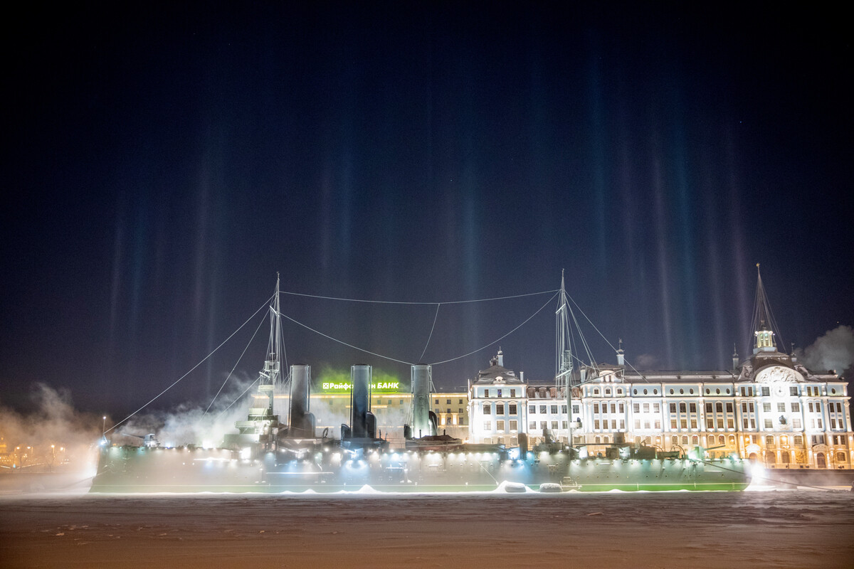 Sankt Peterburg. Križarka Aurora 1. ranga Baltske flote v bližini Petrograjskega nabrežja. V ozadju svetlobni stebri.