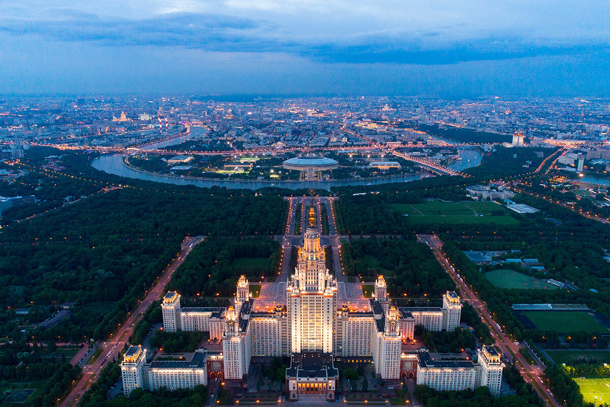 Vista aerea dell’edificio principale dell’Università Statale di Mosca, con sullo sfondo il fiume Moscova. Si riconosce anche lo Stadio Luzhnikí (in passato Stadio Lenin), sede delle Olimpiadi del 1980