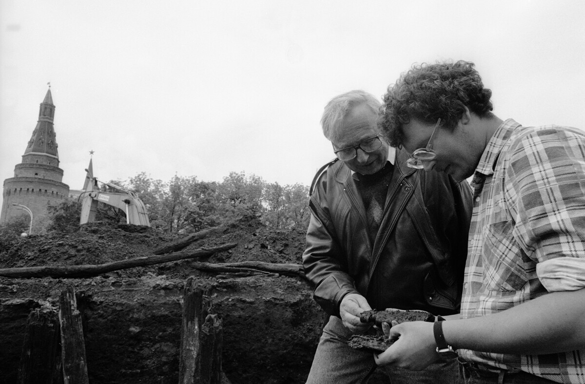 Alexandre Veksler, à gauche, directeur général du Centre de recherche archéologique, examine les découvertes faites sur le site des fouilles de la place du Manège avec l'un des archéologues.