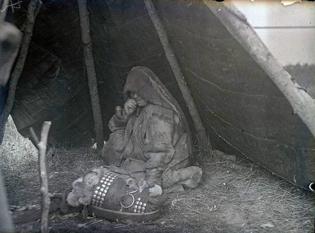 Una donna di etnia Khanty dopo il parto, con il neonato in uno speciale chum (la tradizionale tenda conica) riservato alle puerpere e ai loro figli, 1936