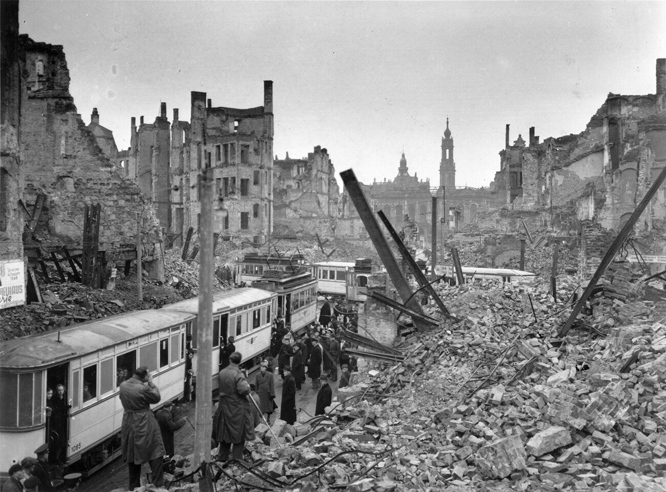 Gente subiendo a los tranvías en medio de las ruinas dejadas por un ataque aéreo aliado en Johannstrasse, Dresde, en la zona soviética de Alemania tras la Segunda Guerra Mundial.