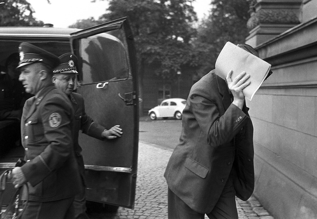 El coacusado en el juicio del doble agente, Heinz Felfe, se cubre la cara con un papel de camino al edificio del tribunal el 8 de julio de 1963. 