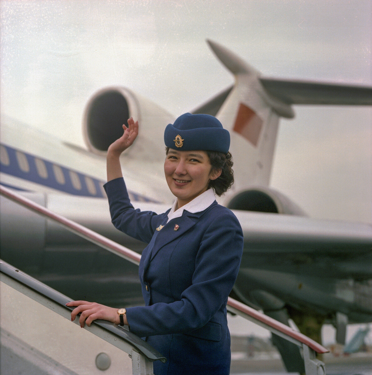 Repubblica Socialista Sovietica Kazaka, aeroporto di Alma-Atá. Gulnara Kurbankhodzhaeva, assistente di volo, davanti a un aereo di linea Tupolev Tu-154, 1983