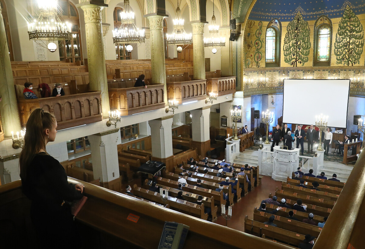 Believers attend an evening service at the Grand Choral Synagogue marking The Day of Salvation and Liberation of European Jews from the Nazis, 2021