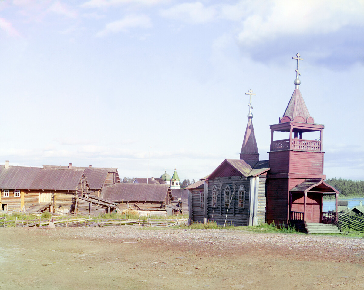 Lizhma village. View of log houses with attached barns. Right: 19th-century church (not extant). Background: Church of St. Nicholas. Summer 1916