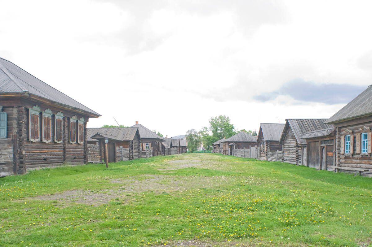 Riserva di Shushenskoe. Vista della strada che porta all’isba di Apollon Zyrjanov. A sinistra: casa Cherkashin. A destra: Casa Potylitsyn. 26 maggio 2015