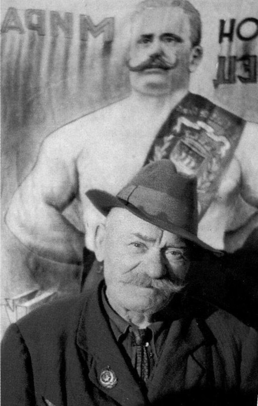 Ivan Poddubny in his later years (after 1939), posing against his own poster 
