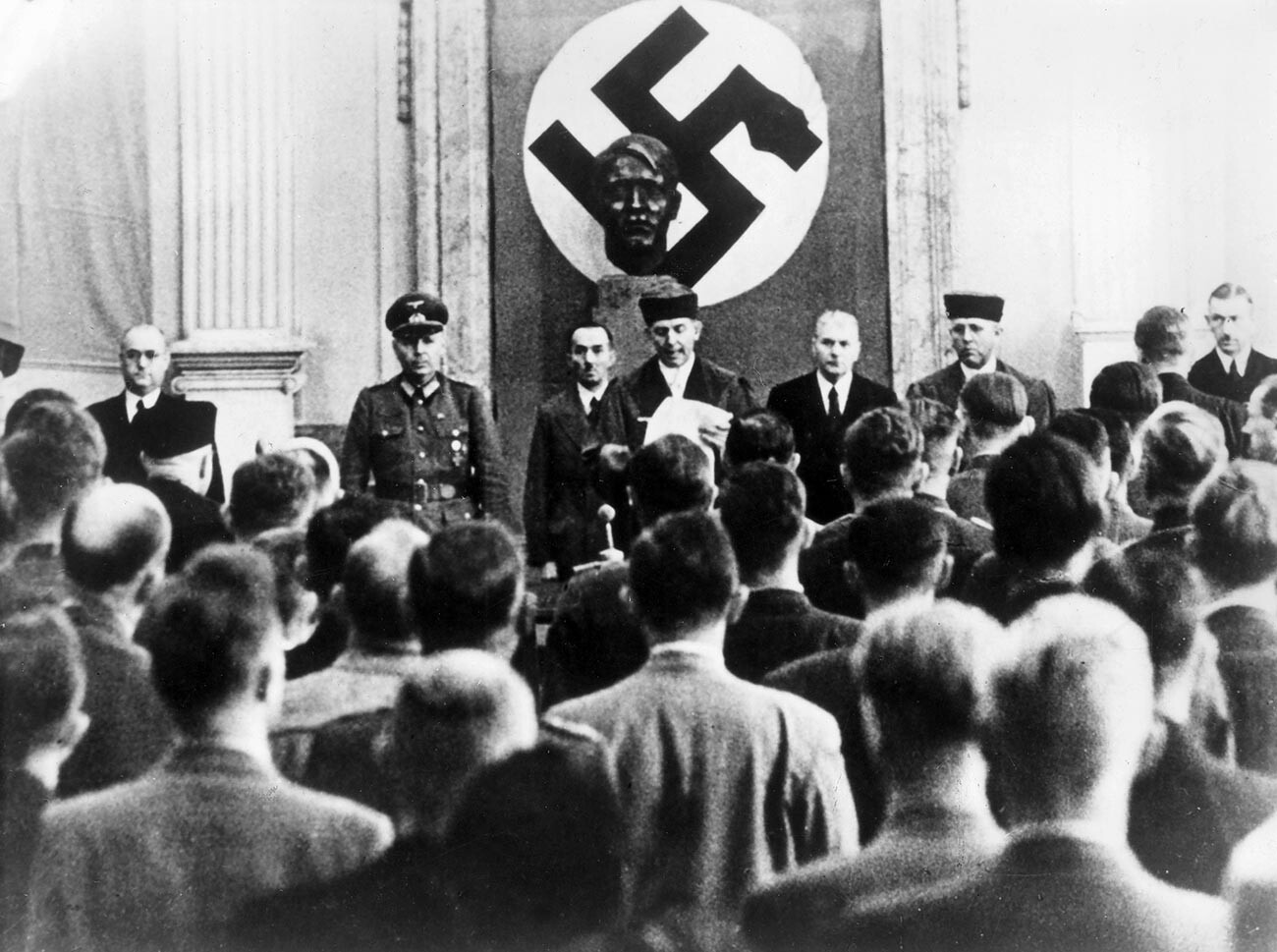 Izrek sodbe v sodni dvorani vrhovnega sodišča. Roland Freisler (v sredini), predsednik ljudskega sodišča, med branjem sodbe. 