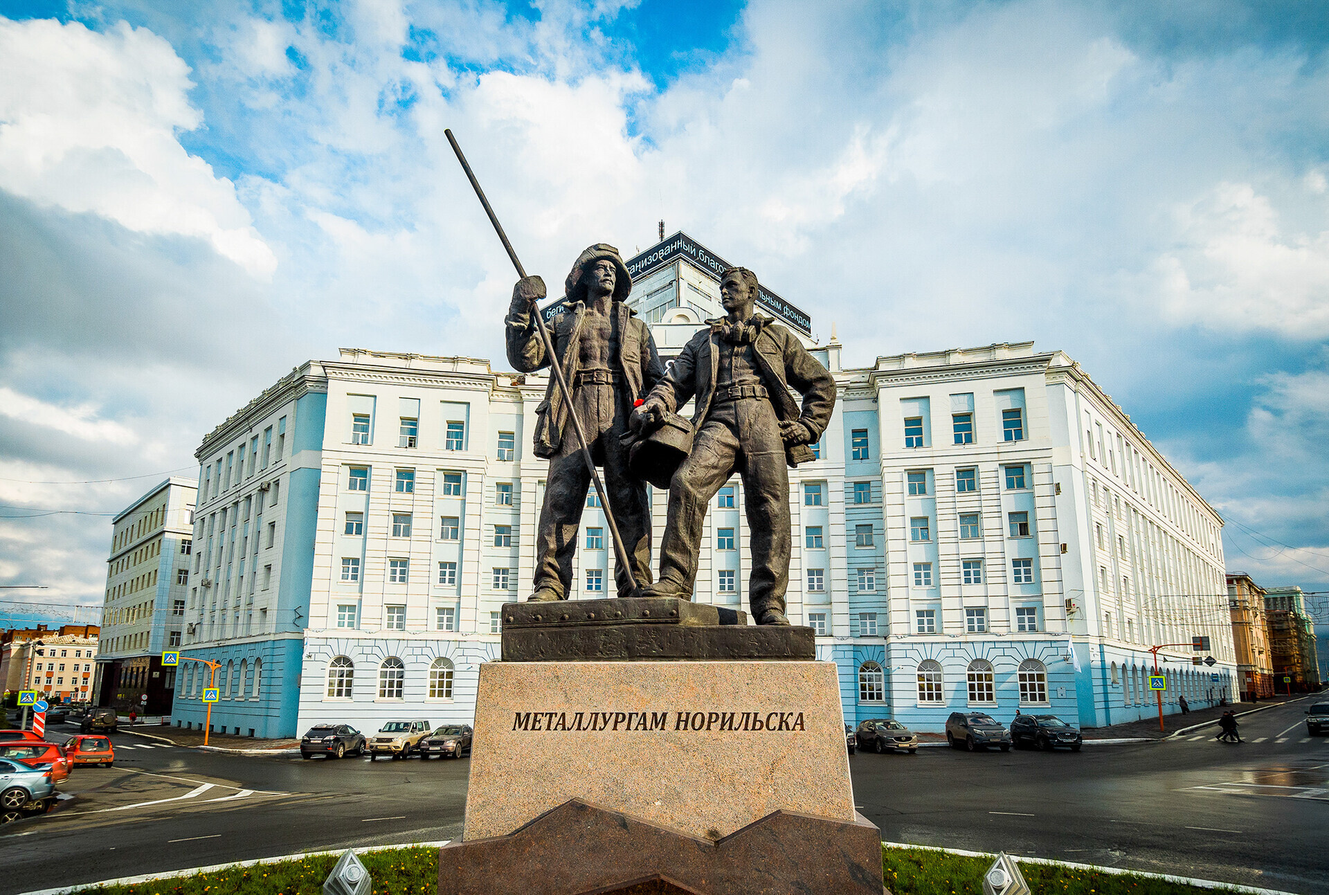 Il monumento ai metallurgici nel centro di Norilsk, inaugurato nel luglio 2020. Vicino è stata lasciata la grande pietra con una scritta di epoca sovietica che prometteva la futura erezione di un obelisco a memoria dei fondatori della città