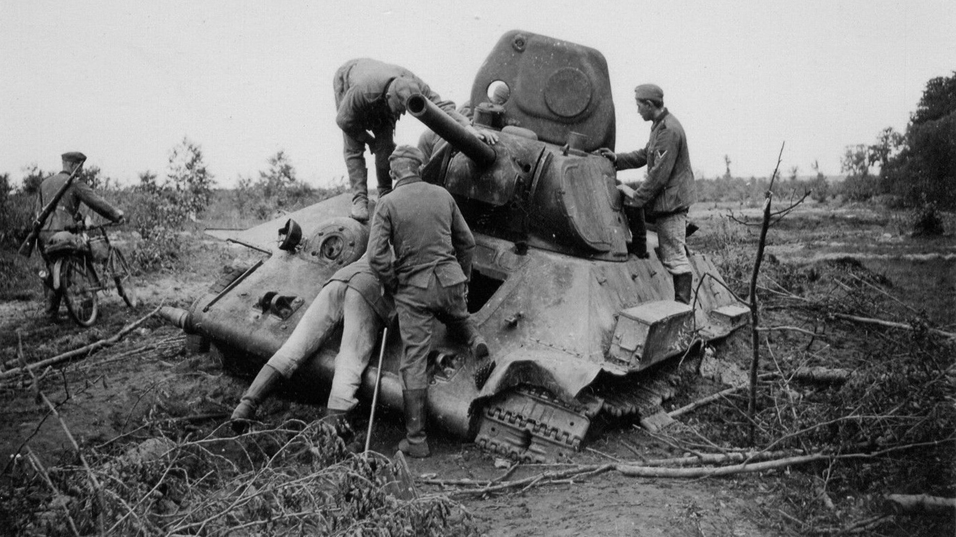 German soldiers examine a destroyed Soviet tank.