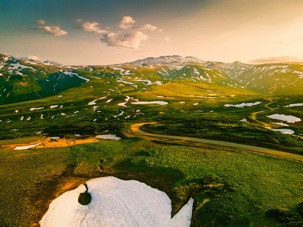 Berge und Vulkane mit Schnee bei Sonnenuntergang auf dem Wiljutschinskij-Pass auf der Halbinsel Kamtschatka