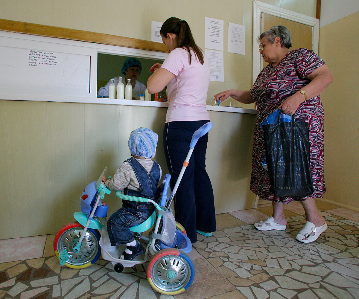 A mother with a baby getting milk mix at a milk kitchen, Ryazan.