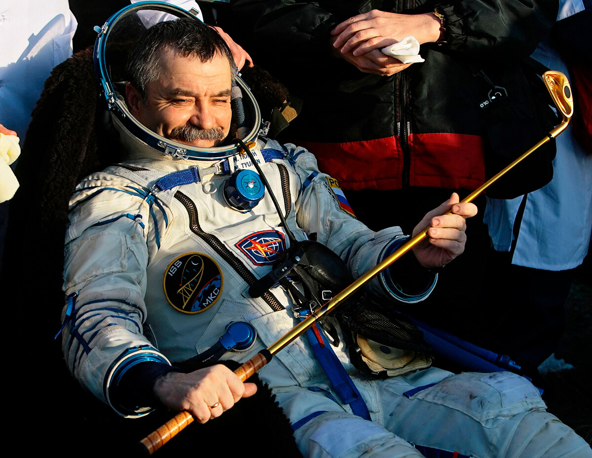 Ruski kozmonavt Mihail Tjurin se nasmehne s palico za golf kmalu po pristanku ruske vesoljske kapsule 