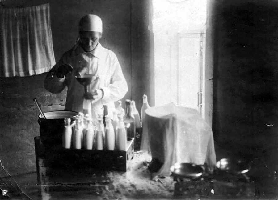 In una molochnaja kuckhnja il latte preparato viene versato nei biberon, 1937