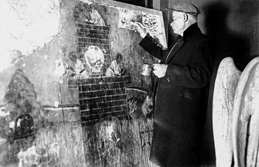 Pavel Yukin at work, toning areas of paint loss in the composition “Construction of the Tower of Babel” after it was mounted on a new support