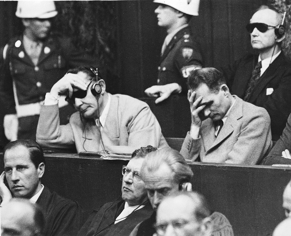 Рудолф Хес, вдясно, държи главата си от болки със стомашни проблеми по време на съдебния процес