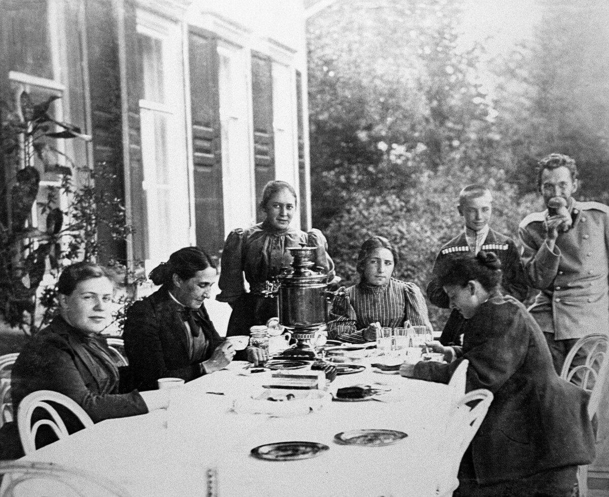 Residents and guests of the Abramtsevo estate drinking tea in the garden. 