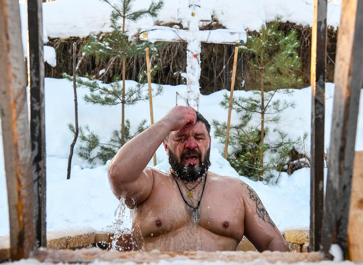 Ein Mann taucht in eiskaltes Wasser zum orthodoxen Dreikönigsfest ein.