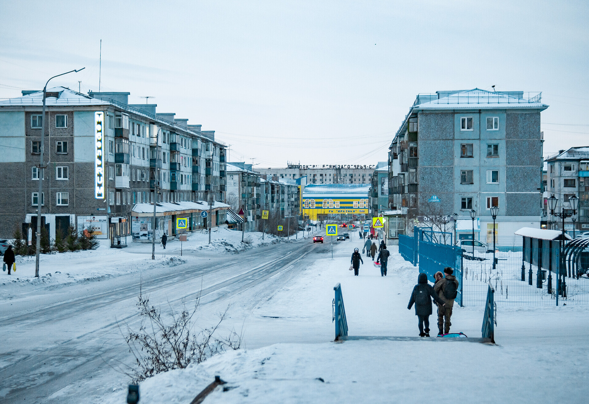 Ecco come appare il centro di Vorkuta. In lontananza c’è la “casa inquietante”, mentre i giovani passeggiano lungo le strade