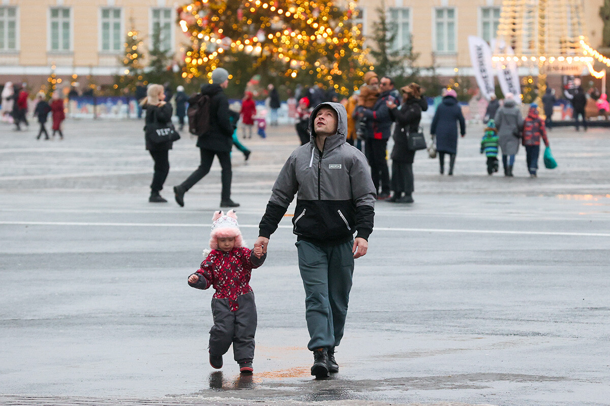 Sankt Peterburg,14. januar 2023: Moški vodi otroka za roko po Dvornem trgu