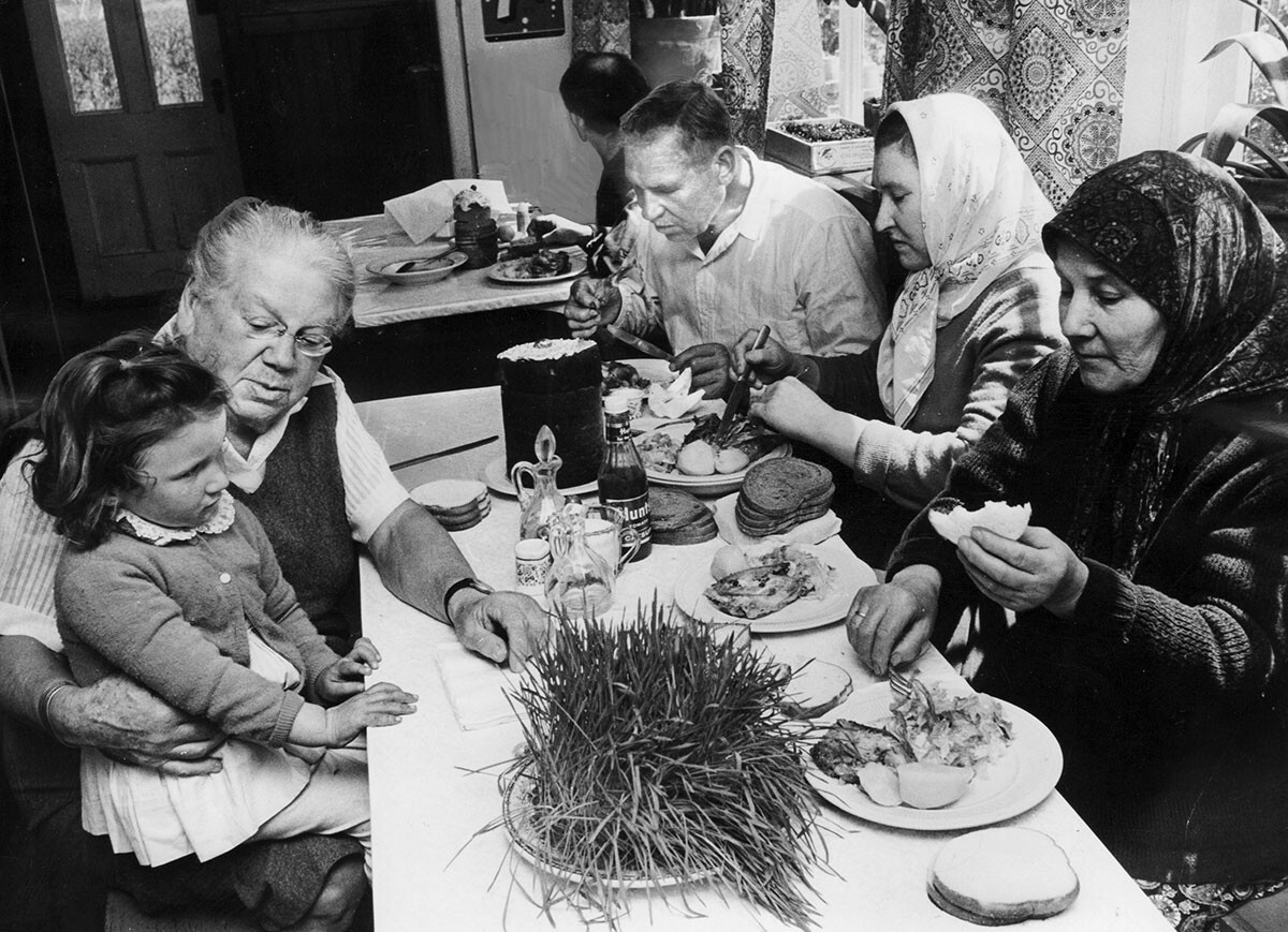 Aleksandra Tolstaja tiene in grembo Arischa Saglan, di 3 anni, mentre consuma un pasto con altri russi alla Reed Farm di Valley Cottage, New York, il 4 maggio 1964