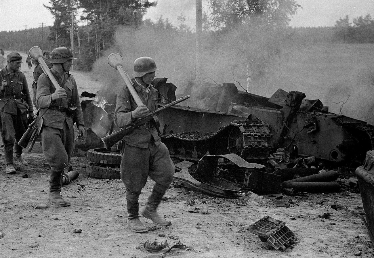 Finski vojaki pehotnega polka 12 si ogledujejo uničen sovjetski tank T-34, ki ga je med bitko pri Tali-Ihantali na severu mesta Viborg uničil nemški napadalni top