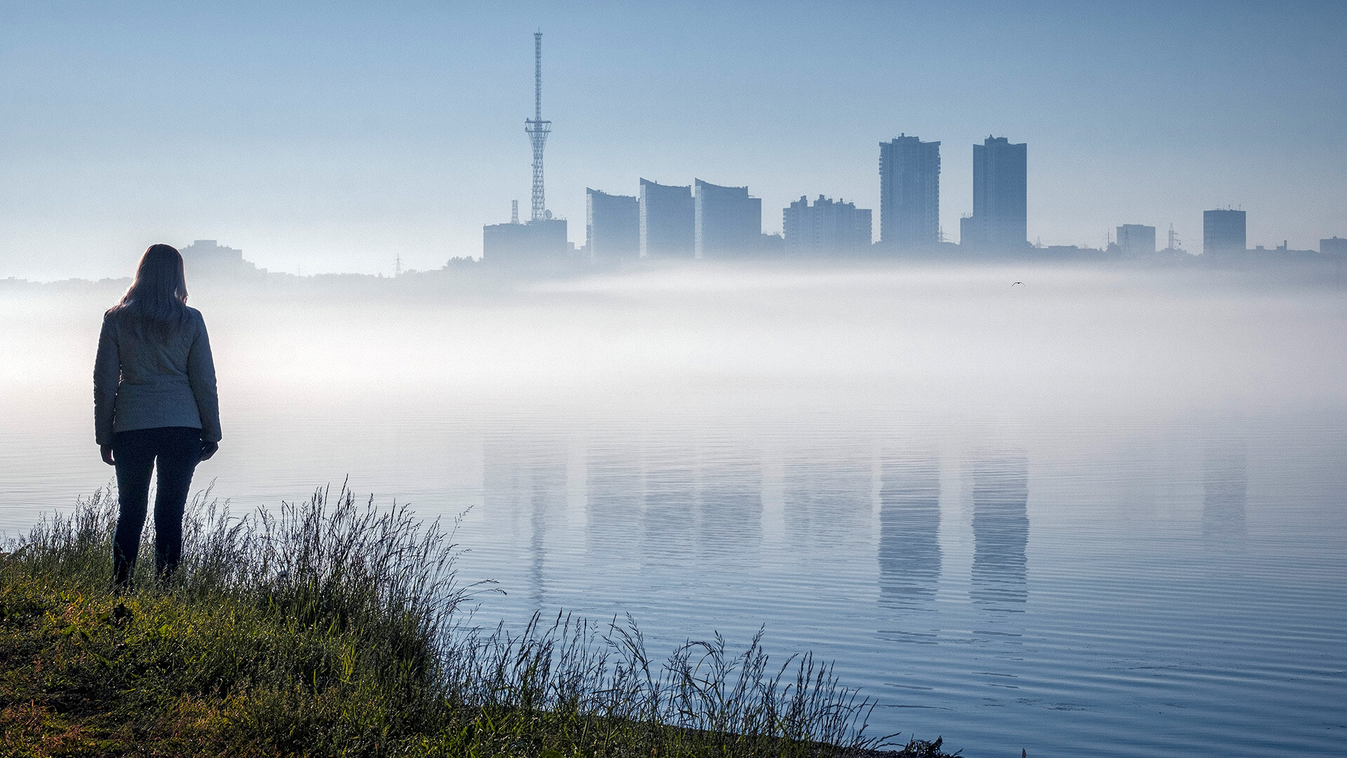 Izjemno megleno jutro nad reko Kama. Po šesti uri so se na drugi strani reke začele pojavljati tipične značilnosti velikega mesta. Mesto Perm. Ural. Rusija.