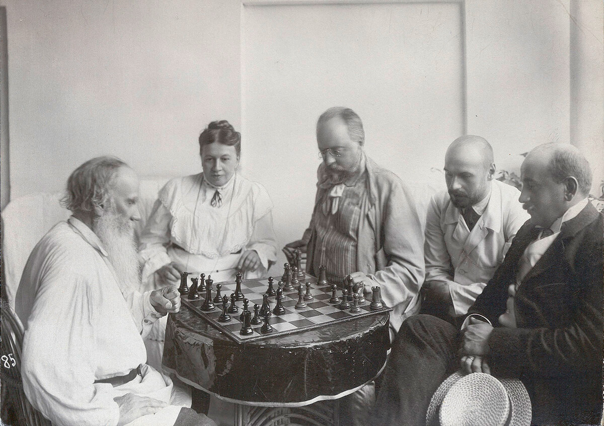 Tolstoy playing chess with son-in-law Mikhail Sukhotin (son Andrei pictured first from right, son Mikhail - second from right), 1908.