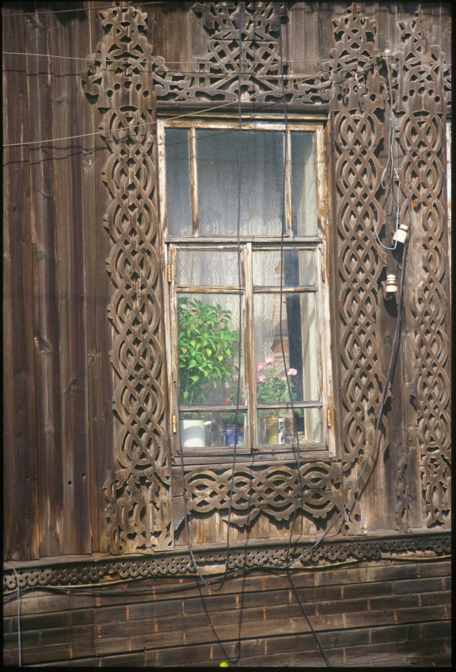 Decorative window frame of wooden house (late 19th century), May First Street. August 24, 1999