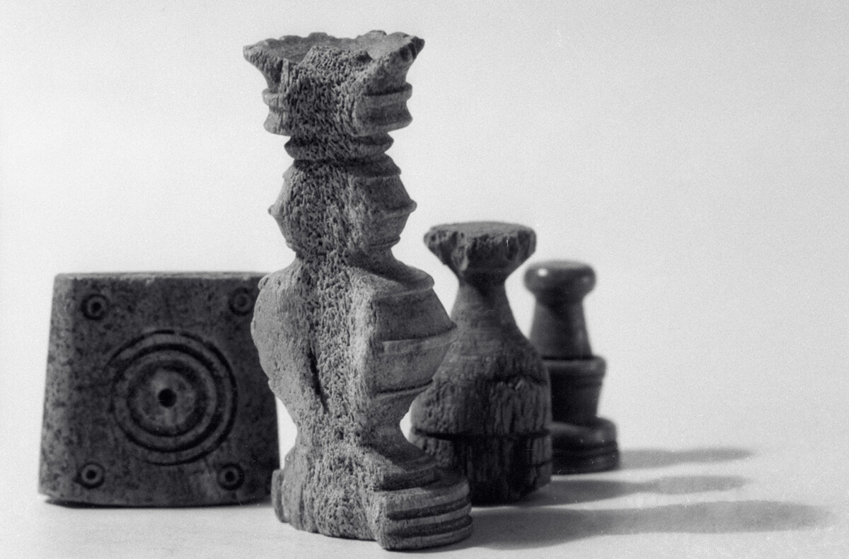 A dice (L) and three chess pieces, 17th century. Such dice could be used for fortune telling as well