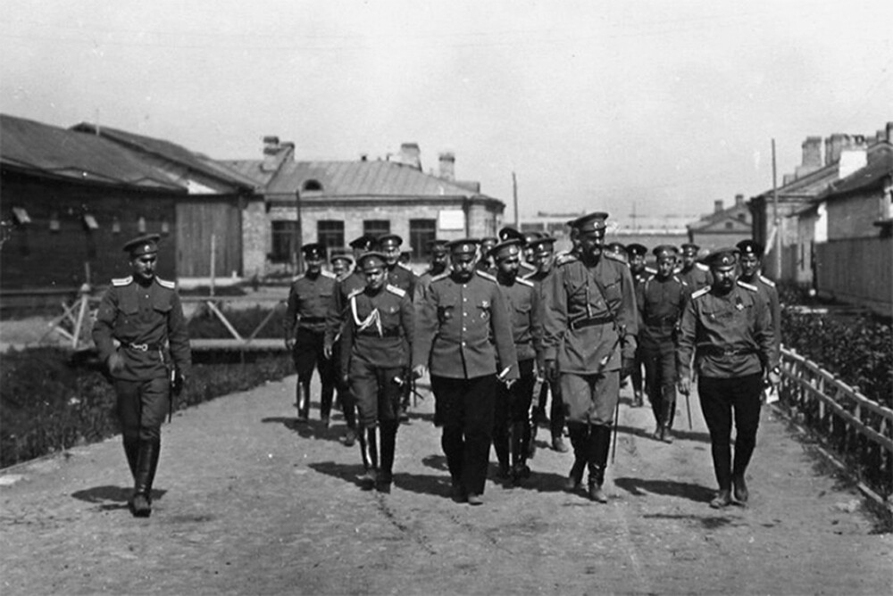 Le grand-duc Alexandre Mikhaïlovitch (devant le groupe) et les officiers qui l'ont accompagné dans l'un des hangars du détachement d'aviation du Corps de la Garde lors d'une visite d'un aérodrome. Petrograd. 1ère et 7ème compagnies d'aviation. 1914-1916