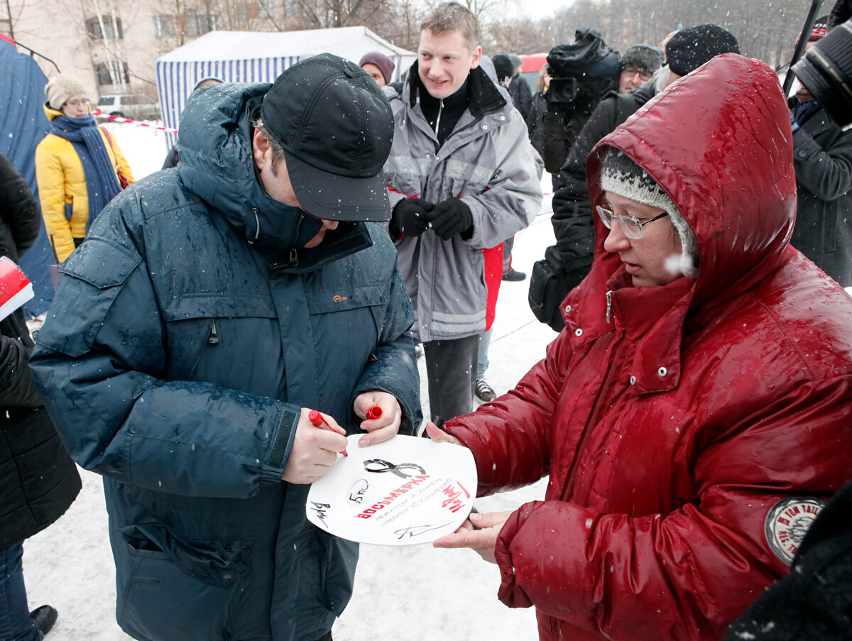 Le réalisateur Alekseï Outchitel (à gauche) signe une plaque marquant le début du tournage du nouveau film Huit dans la ville de Sestroretsk