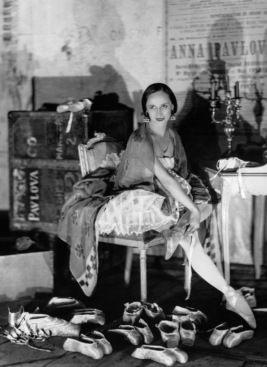 Anna Pavlova prepares her many pairs of ballet slippers in her dressing room before a performance in Paris