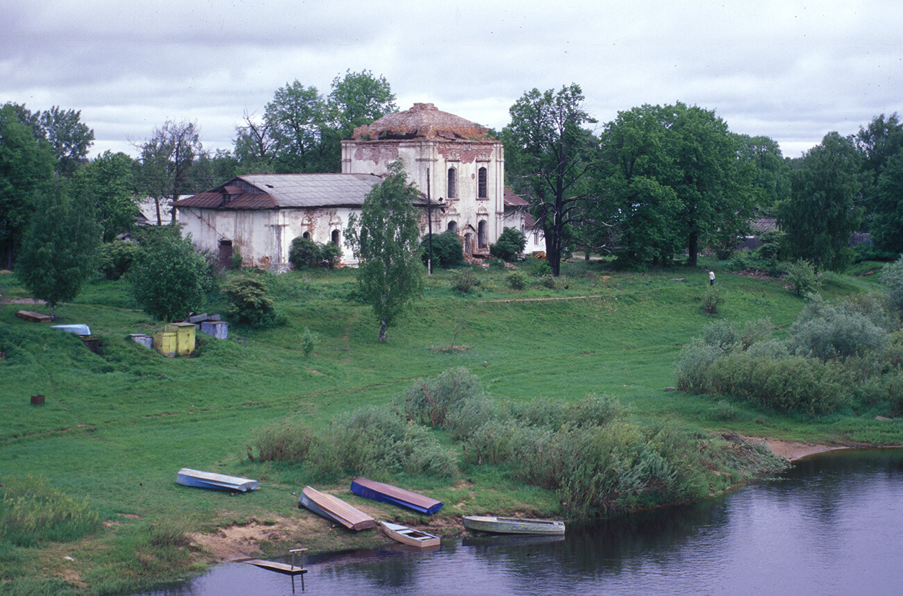 Ustiuzhna. Church of Dormition of the Virgin (also Church of Descent of Holy Spirit). Southwest view with left bank of Mologa River. Built in 1781, closed in 1939, used as food-processing plant. May 22, 2001