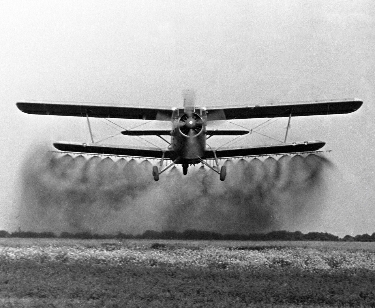 Letalo An-2 preizkuša novo opremo za škropljenje polj. 