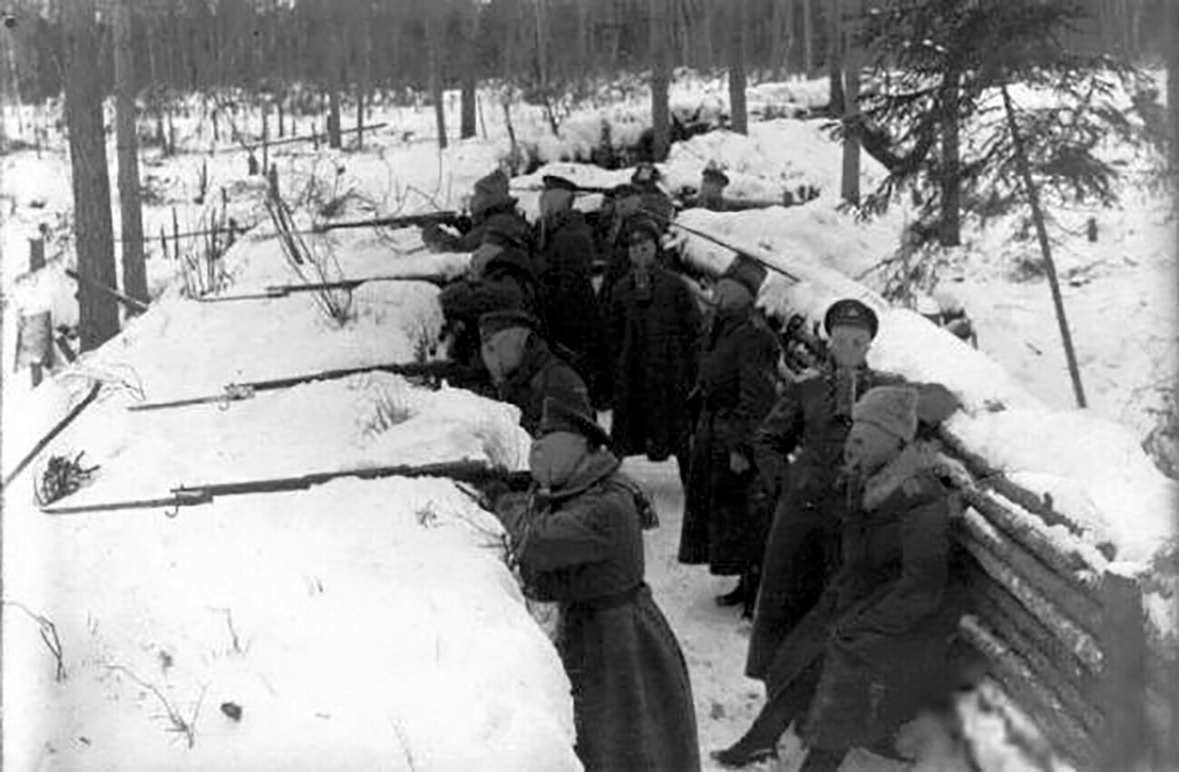 Fuzileiros letões com máscaras de gás em posições de combate durante a operação de Mitau da Primeira Guerra Mundial.