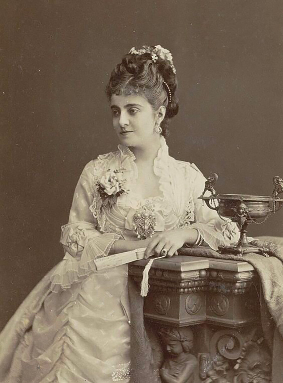 Фотография женщины в парадном платье. Середина 1870-х. Снова в моде высокие причёски.