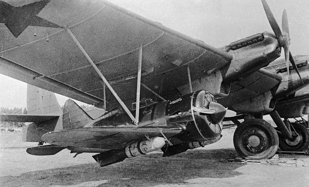 Un caza I-16 suspendido bajo el ala de un bombardero pesado TB-3.